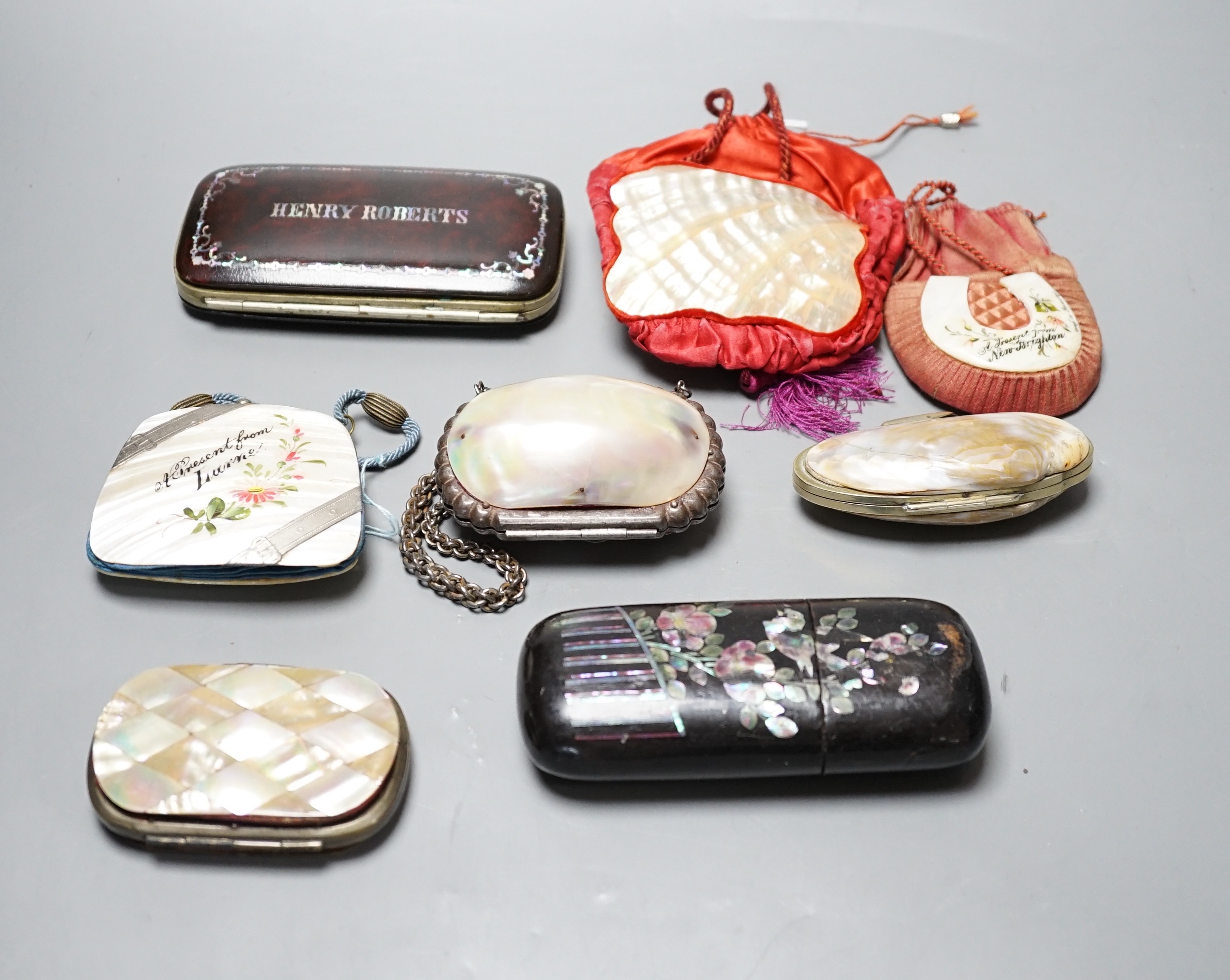 A collection of six mother of pearl souvenir purses, possibly from a grand tour and a papier-mâché mache card case and glasses case, card case 14 cms wide